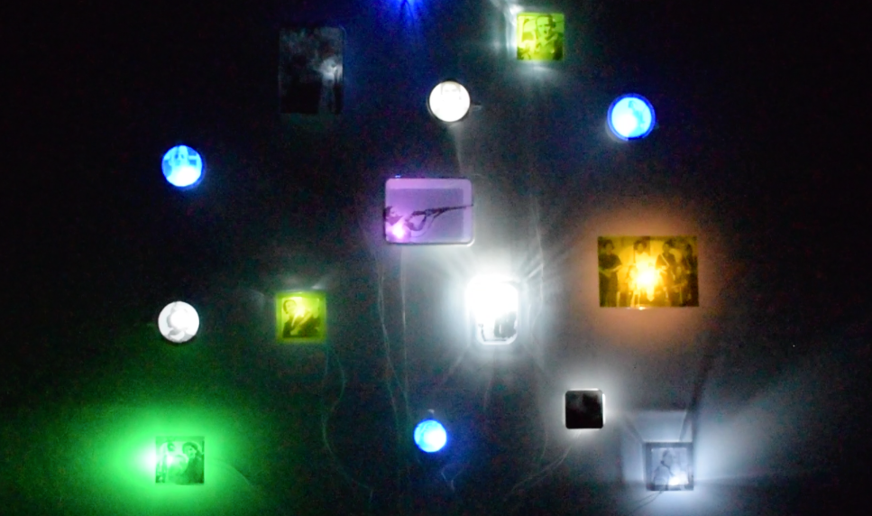 Exhumacion_obsolescencia_Brisa - BRISA MP Dark wall with multicolored illuminated squares and circular lights forming an abstract light installation.