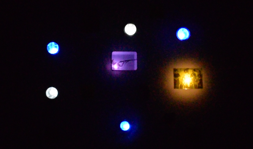 Imagen_archivo_tecnologias_BrisaMP - BRISA MP Dark wall with blue LED lights arranged around a small purple card and a warm yellow photograph on the right.